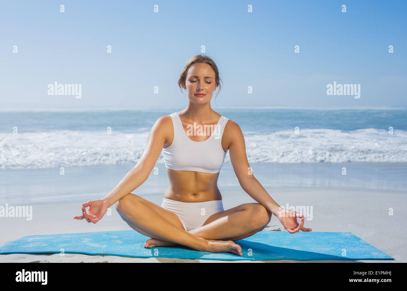Fit calm woman sitting in lotus pose on the beach Stock Photo - Alamy