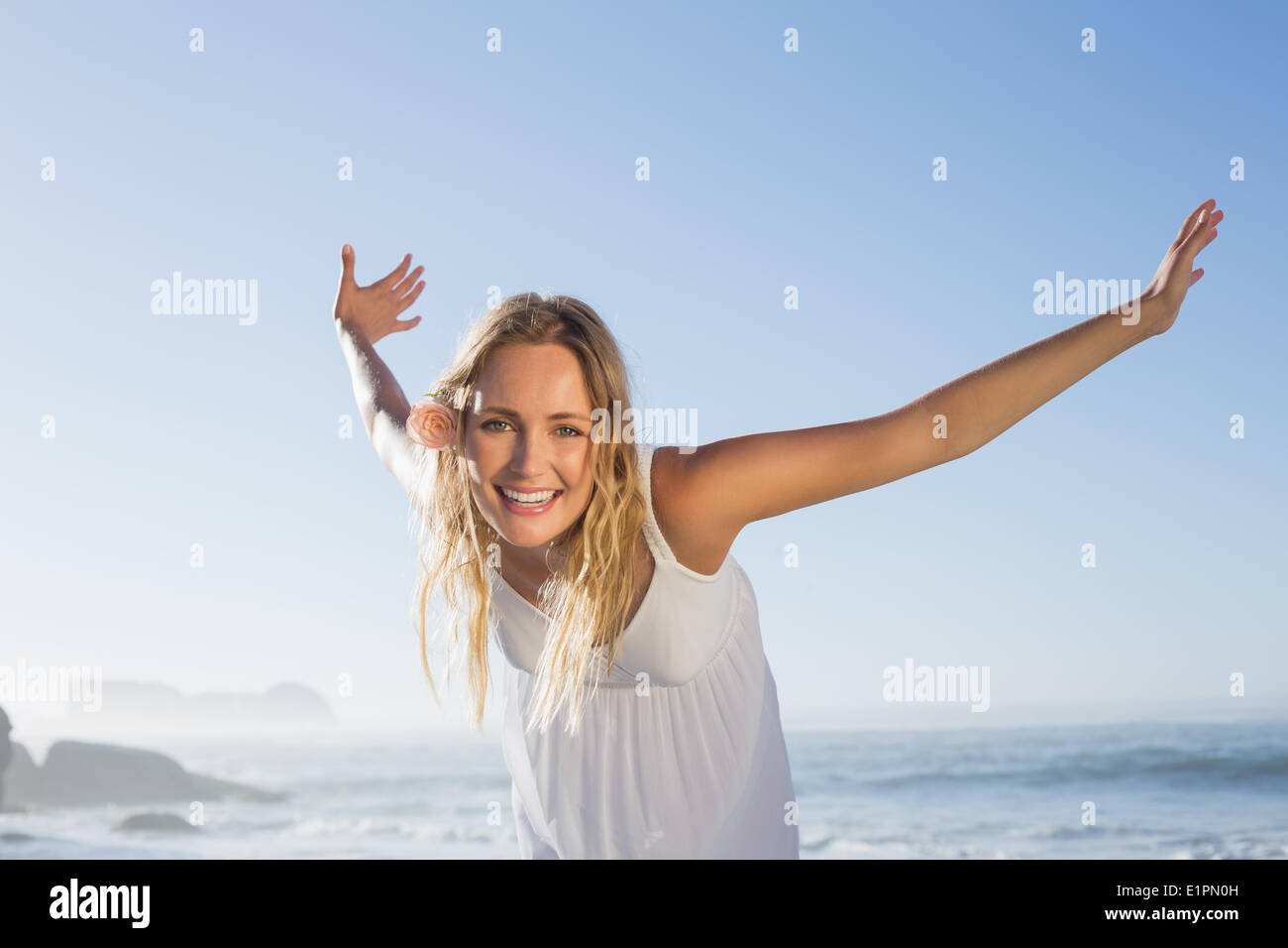 Pretty blonde smiling at the beach in white sundress Stock Photo - Alamy