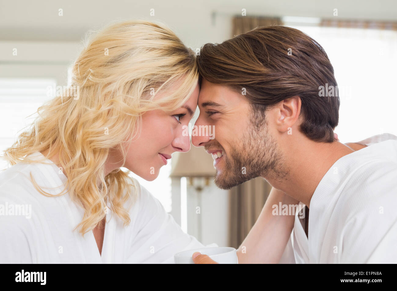 Cute couple in bathrobes touching heads Stock Photo