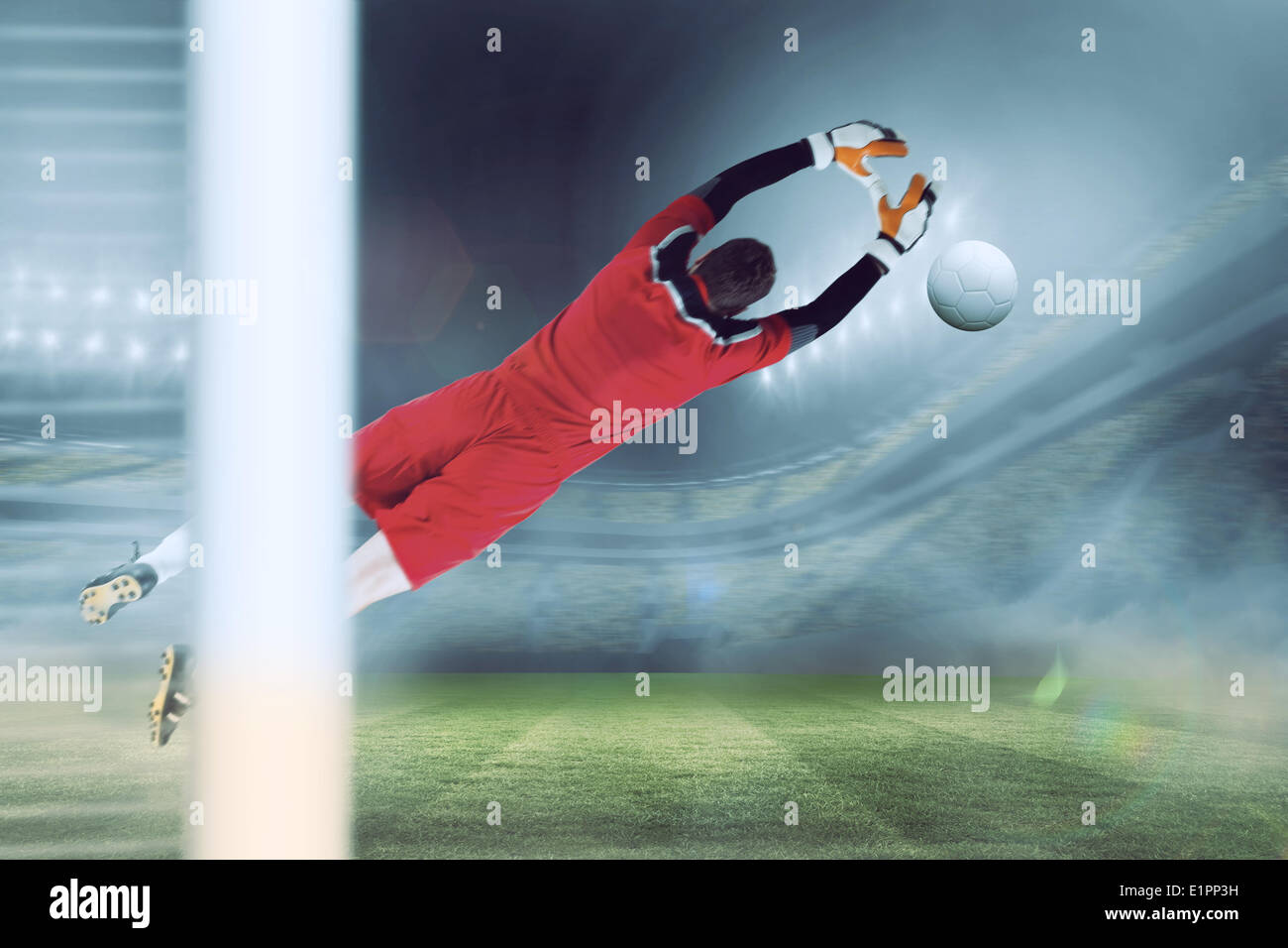 Composite image of goalkeeper in red jumping up Stock Photo Alamy