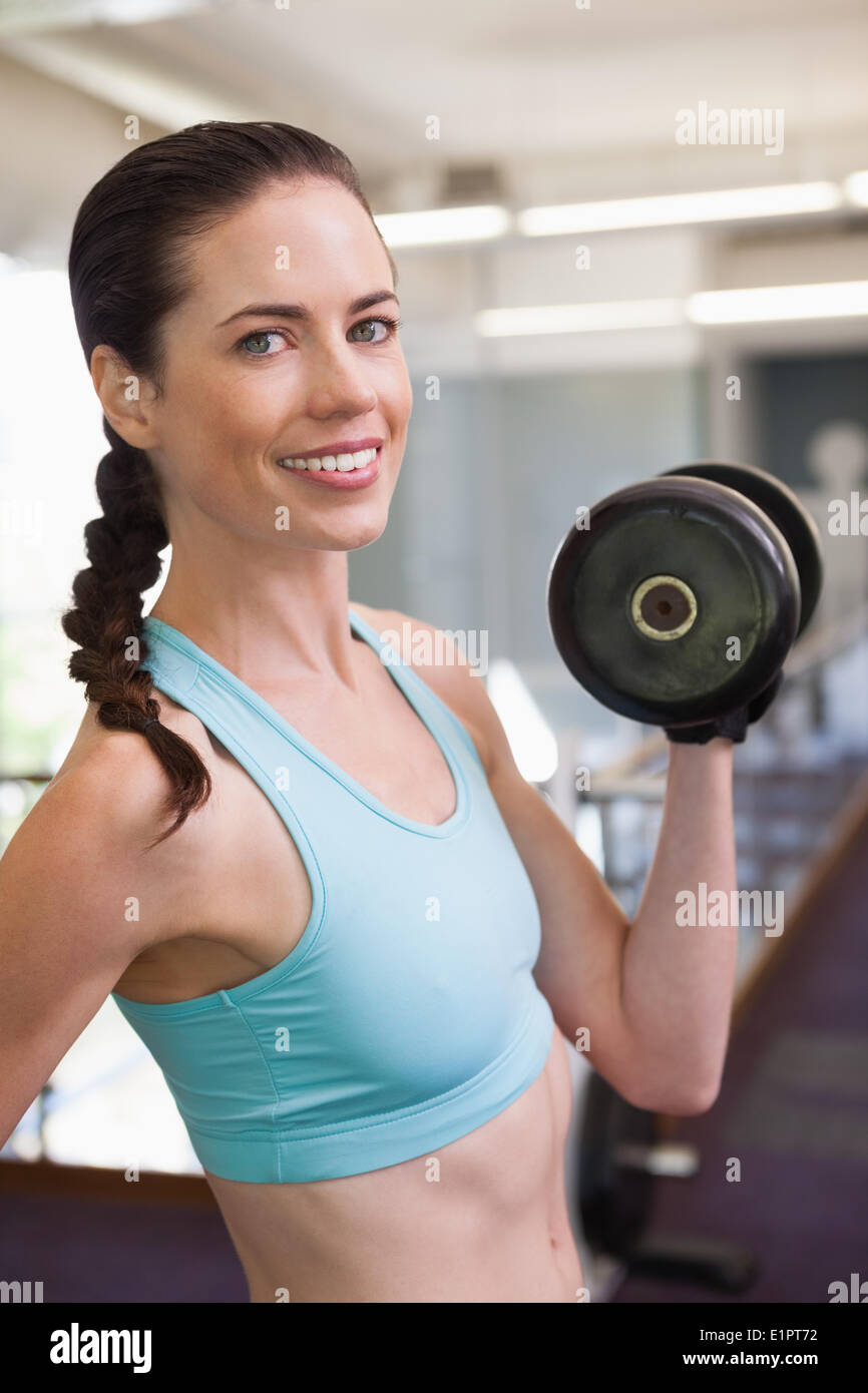 Smiling woman lifting heavy dumbbells Stock Photo Alamy
