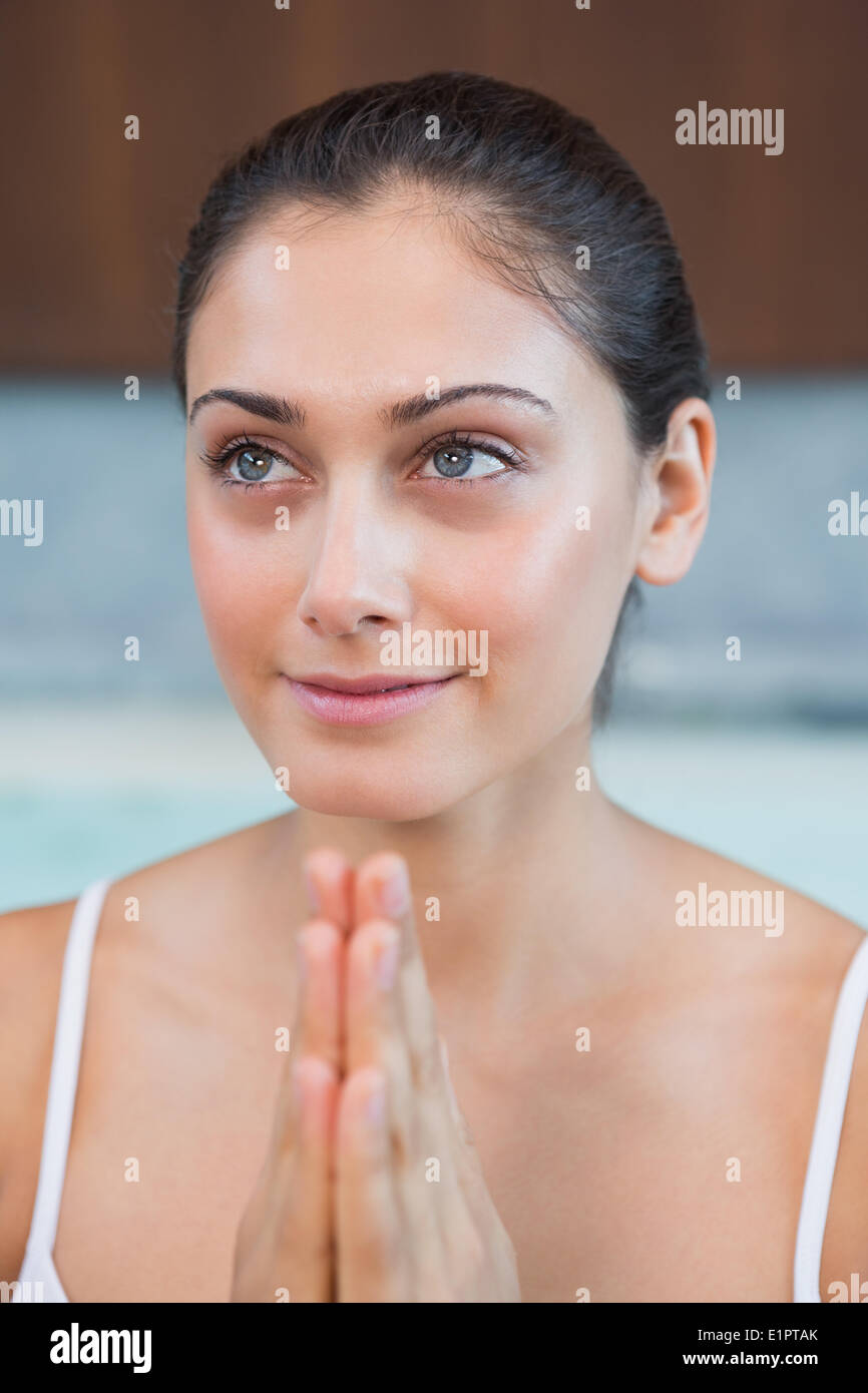 Peaceful woman in white sitting with hands together Stock Photo Alamy