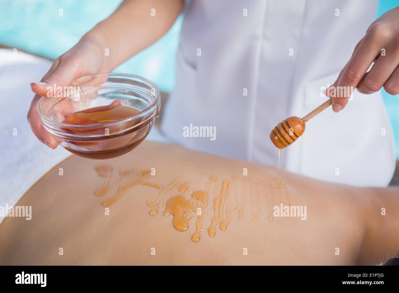 Woman getting a honey beauty treatment poolside Stock Photo