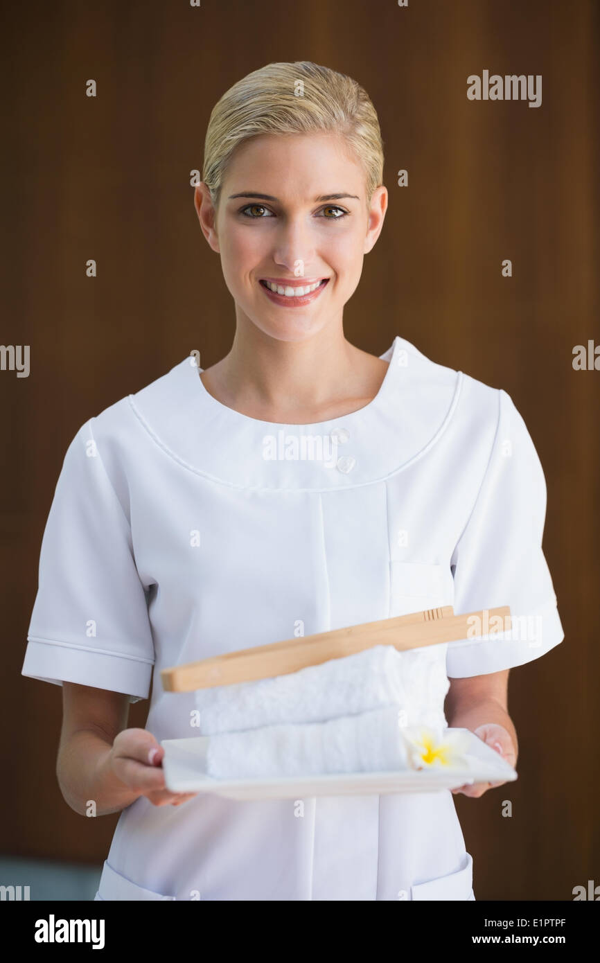 Smiling beauty therapist holding white towels Stock Photo
