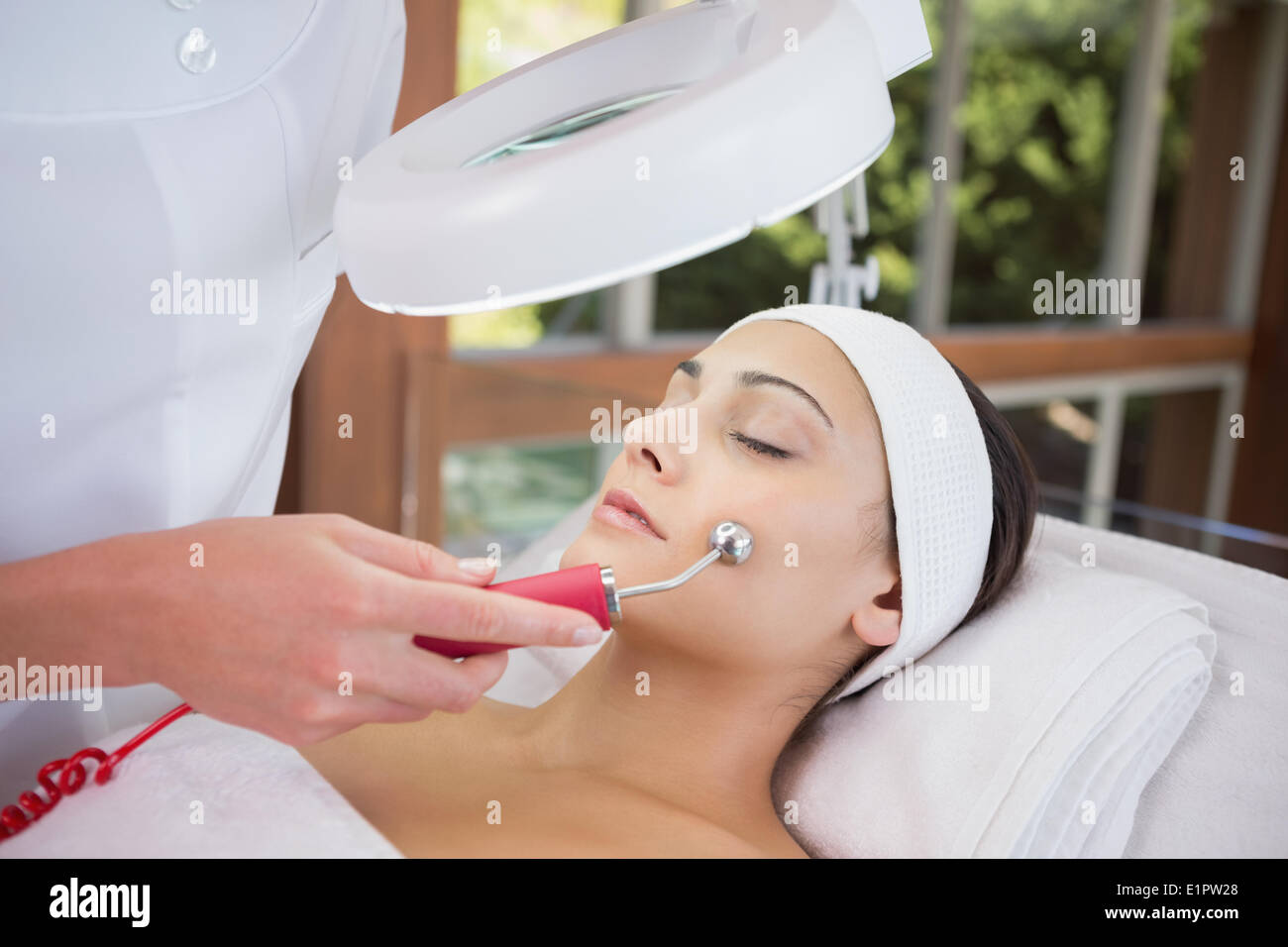 Peaceful brunette getting micro dermabrasion from beauty therapist Stock Photo