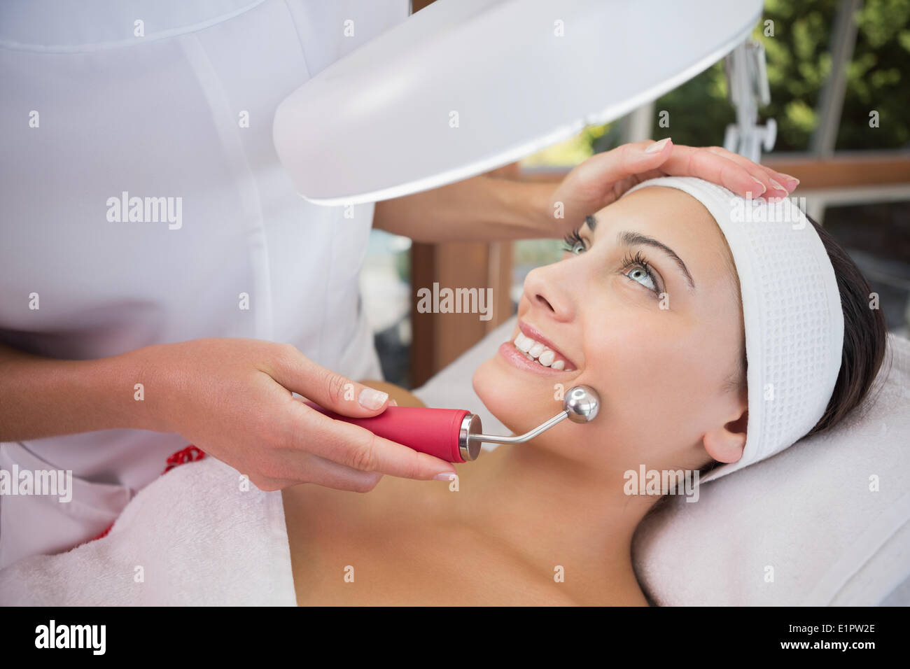 Peaceful brunette getting micro dermabrasion from beauty therapist Stock Photo