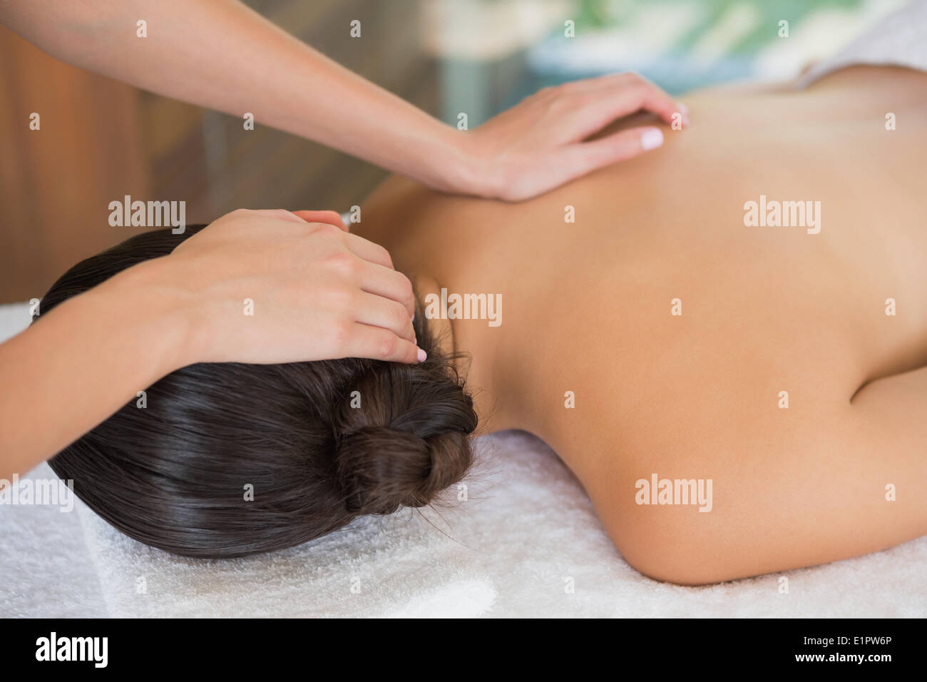 Brunette enjoying a massage lying on towel Stock Photo