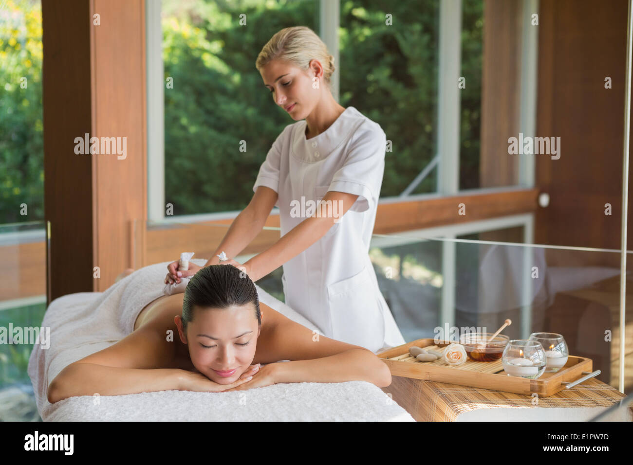 Content brunette enjoying a herbal compress massage Stock Photo