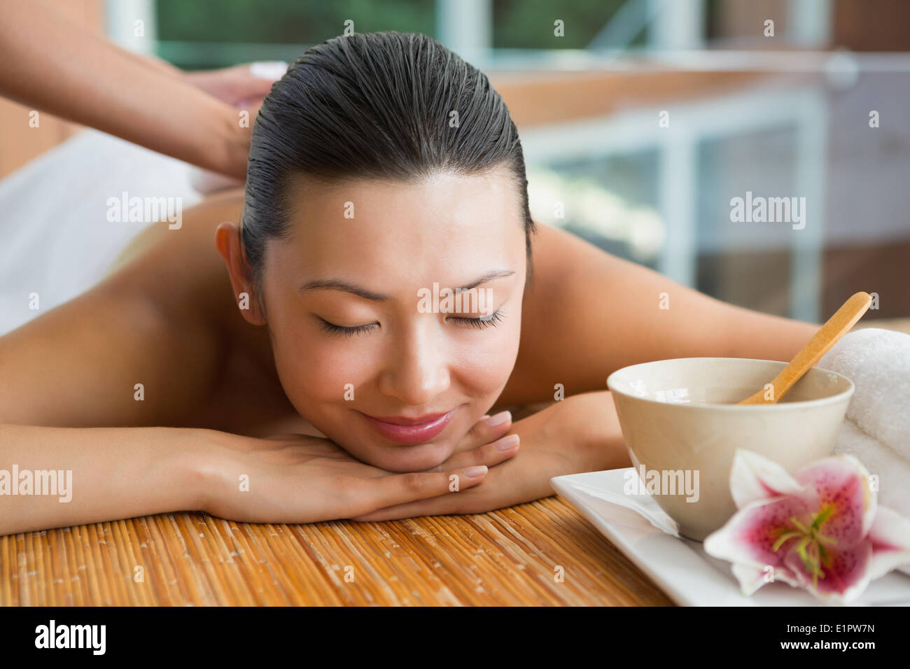 Smiling brunette getting a herbal compress massage Stock Photo