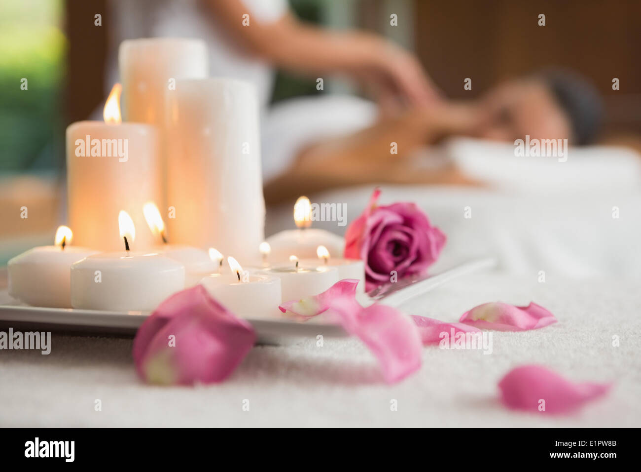 Candles and rose petals on massage table Stock Photo