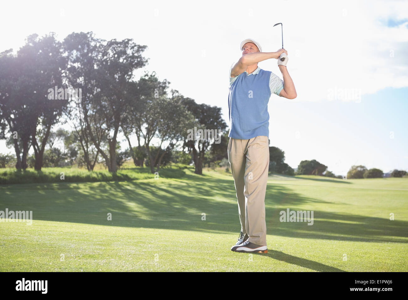 Golfer swinging on the grass Stock Photo