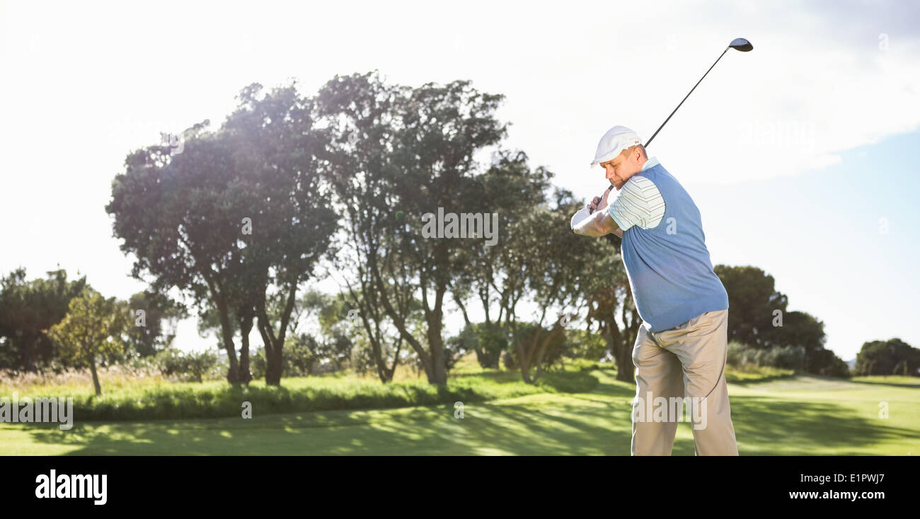 Golfer swinging on the grass Stock Photo