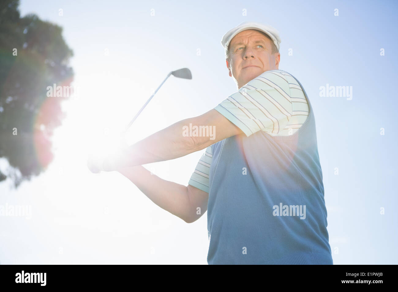 Golfer taking a shot and smiling Stock Photo