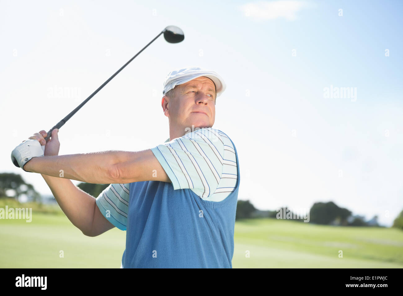 Concentrating golfer taking a shot Stock Photo