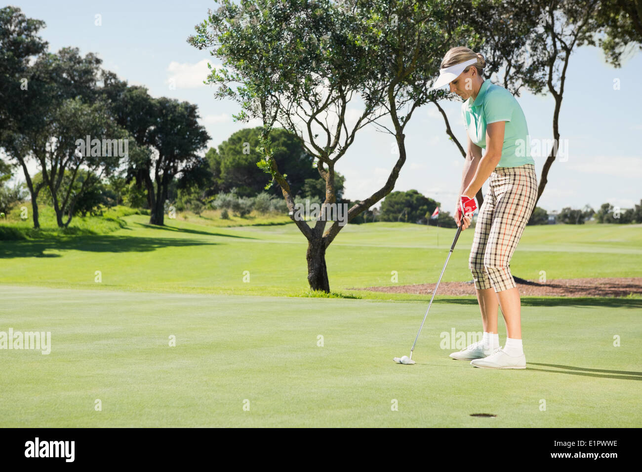 Female golfer putting her ball Stock Photo Alamy