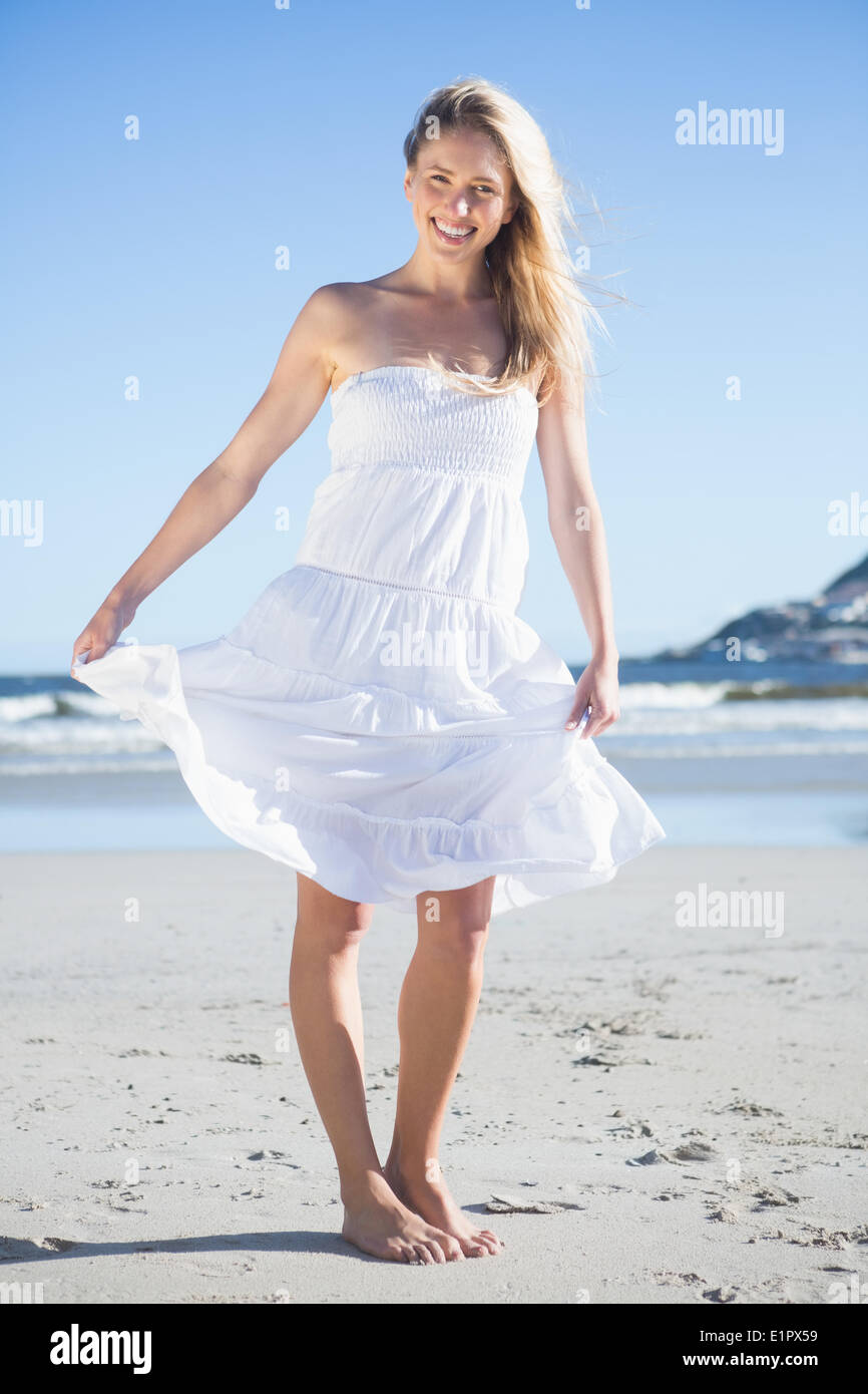 Woman in white dress smiling at camera on the beach Stock Photo - Alamy