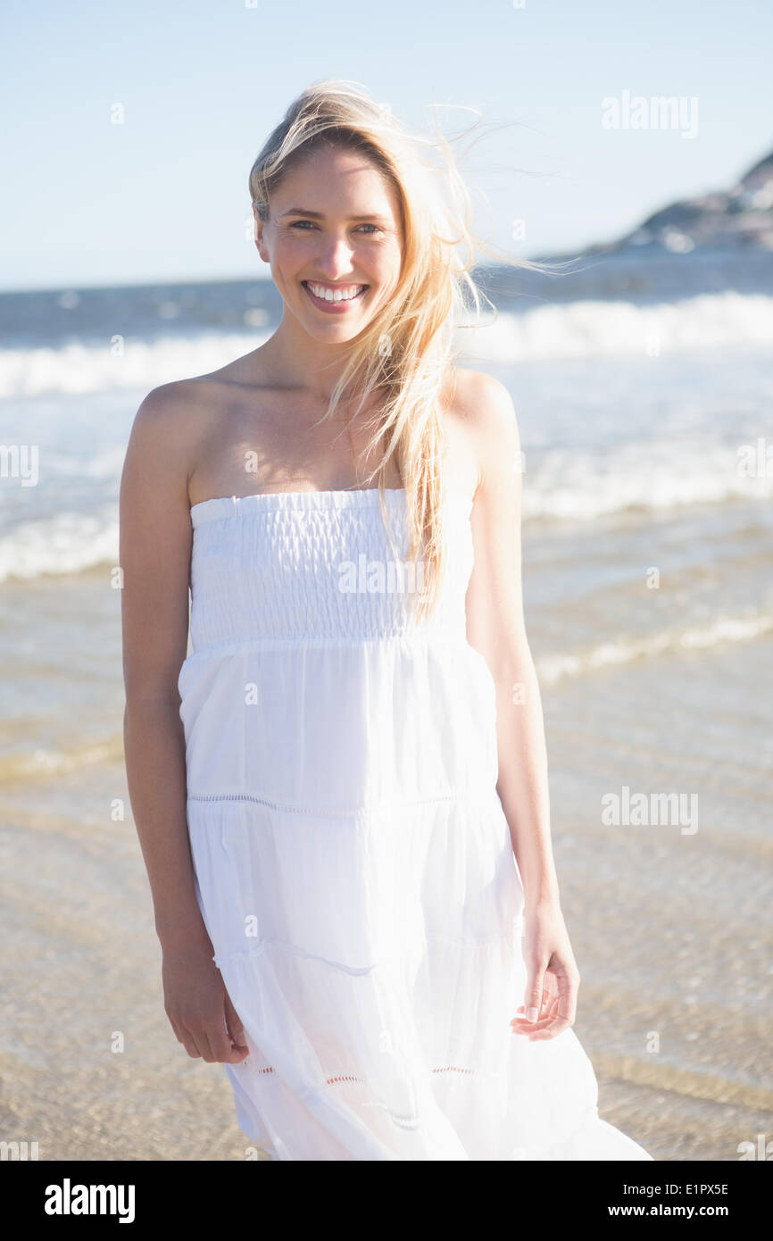 Woman in white dress smiling at camera on the beach Stock Photo - Alamy
