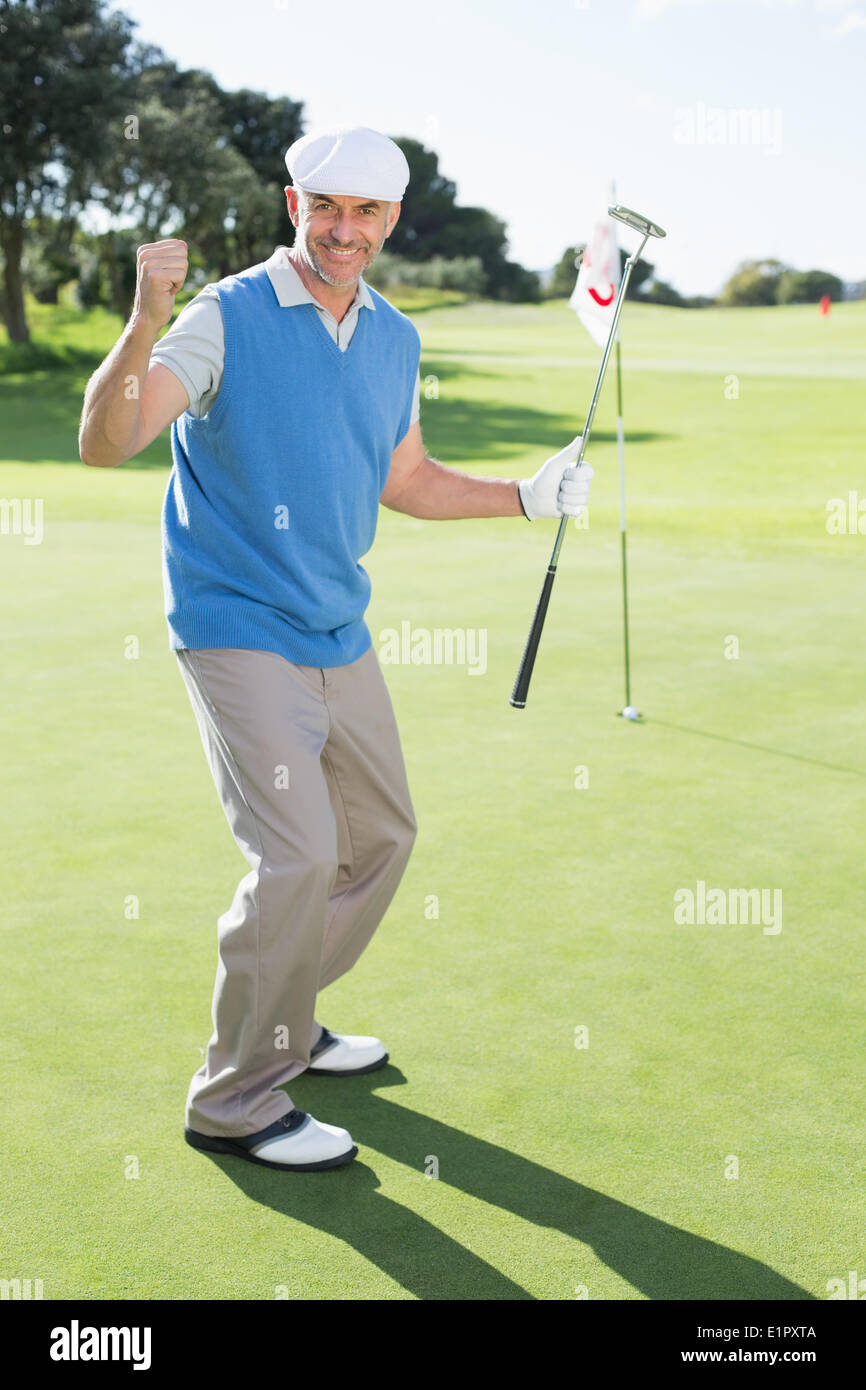 Happy golfer cheering on putting green at eighteenth hole Stock Photo