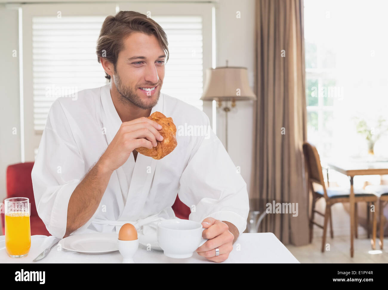 Handsome man having breakfast in his bathrobe Stock Photo