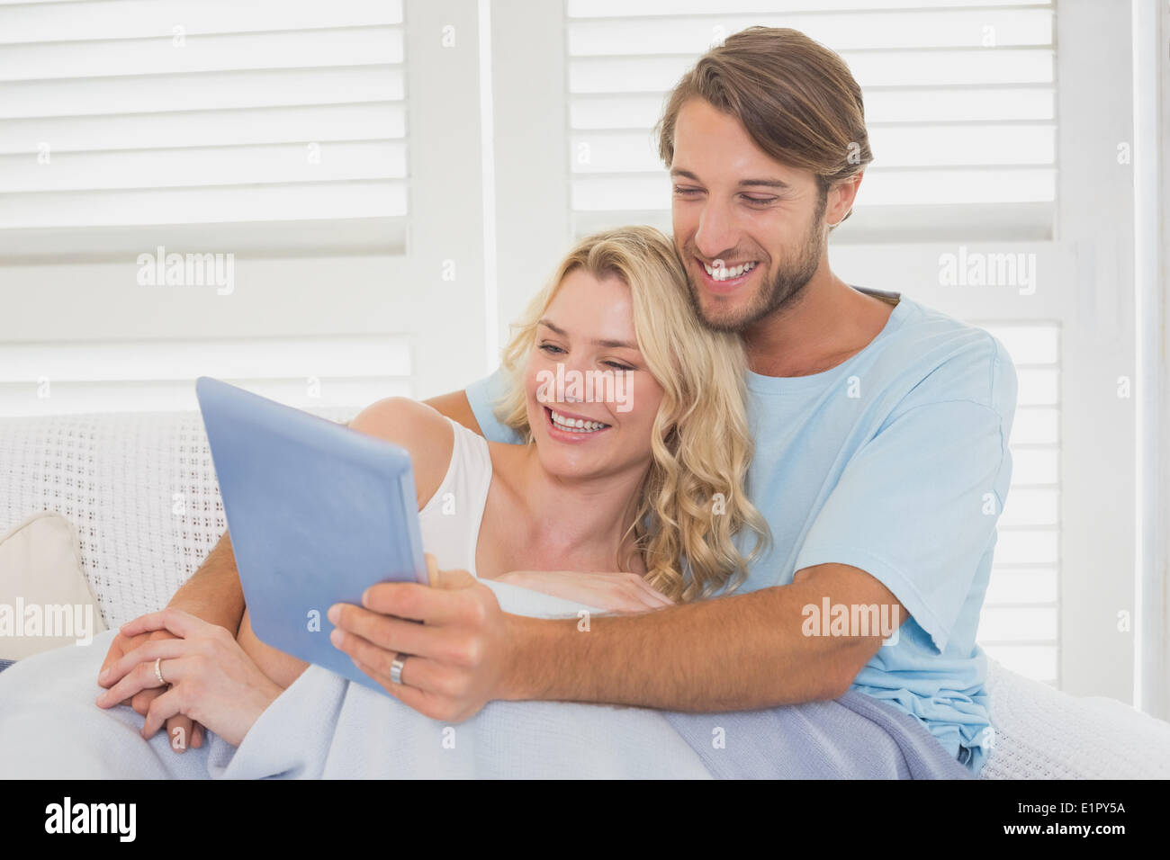 Young couple using tablet pc on the couch Stock Photo