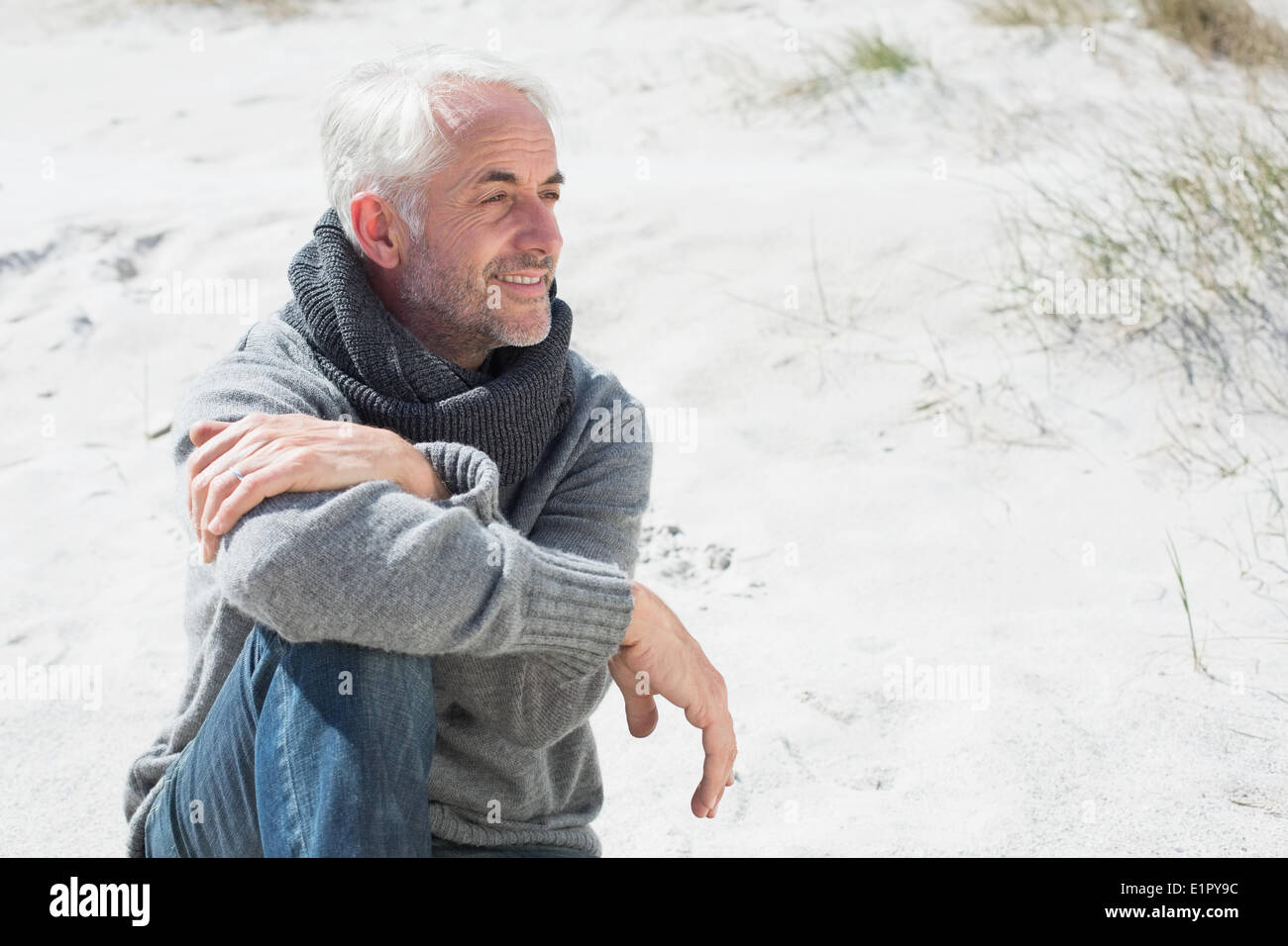 Attractive man smiling on the beach in scarf Stock Photo