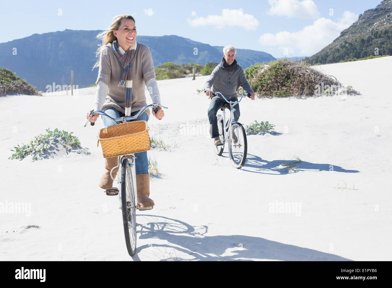 Carefree couple going on a bike ride on the beach Stock Photo