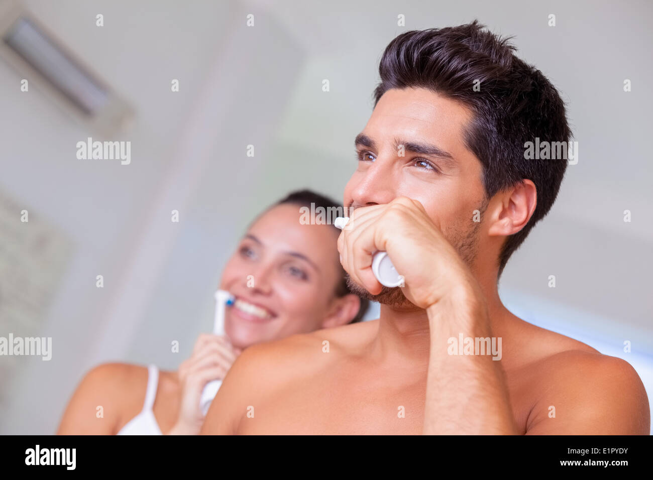 Attractive couple brushing their teeth in the morning Stock Photo