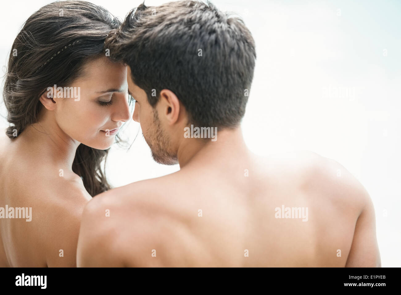 Attractive couple sitting poolside smiling Stock Photo