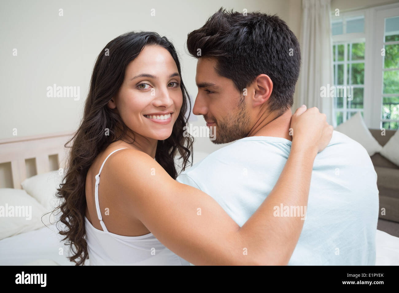 Attractive couple sitting on bed Stock Photo