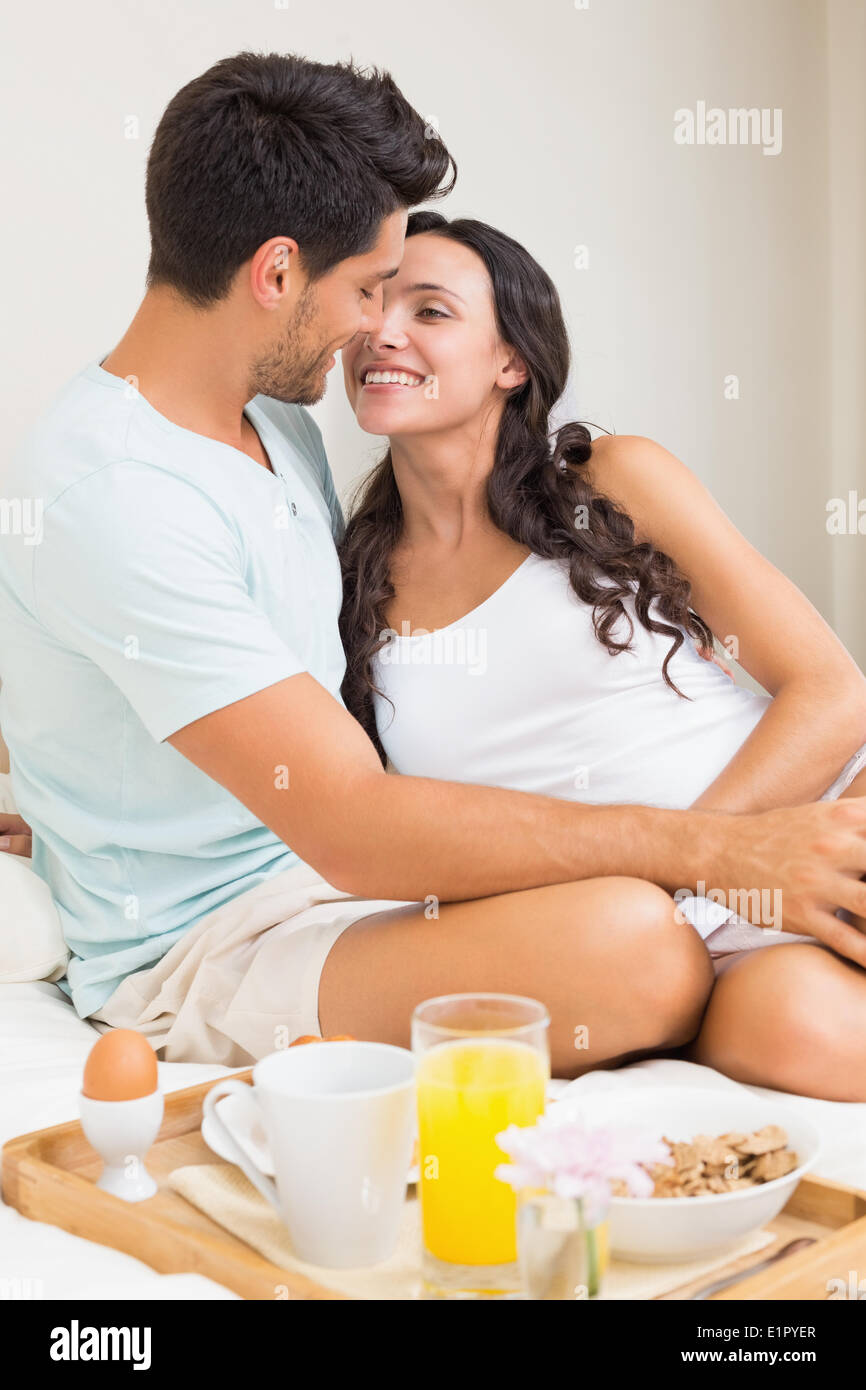 Attractive couple having breakfast in bed Stock Photo