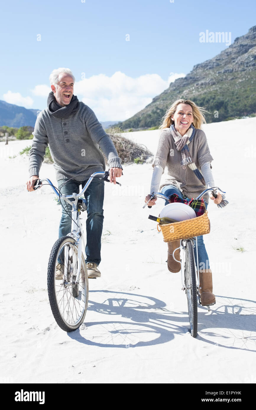 Carefree couple going for a bike ride and picnic on the beach Stock Photo