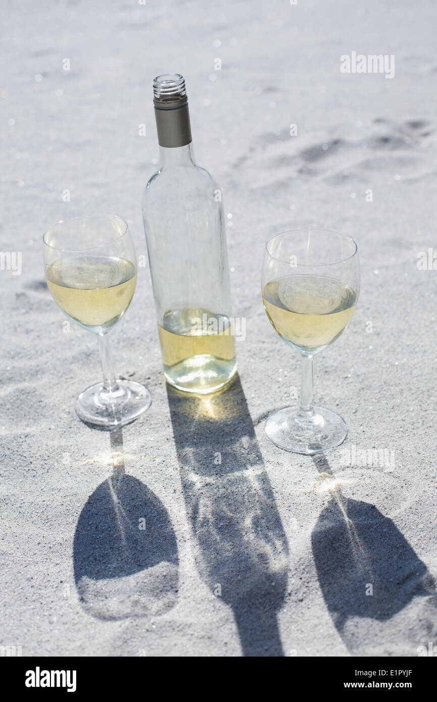 White wine bottle and glasses on the sand Stock Photo - Alamy