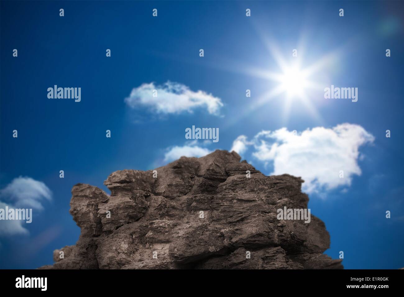 Large rock overlooking bright blue sky Stock Photo