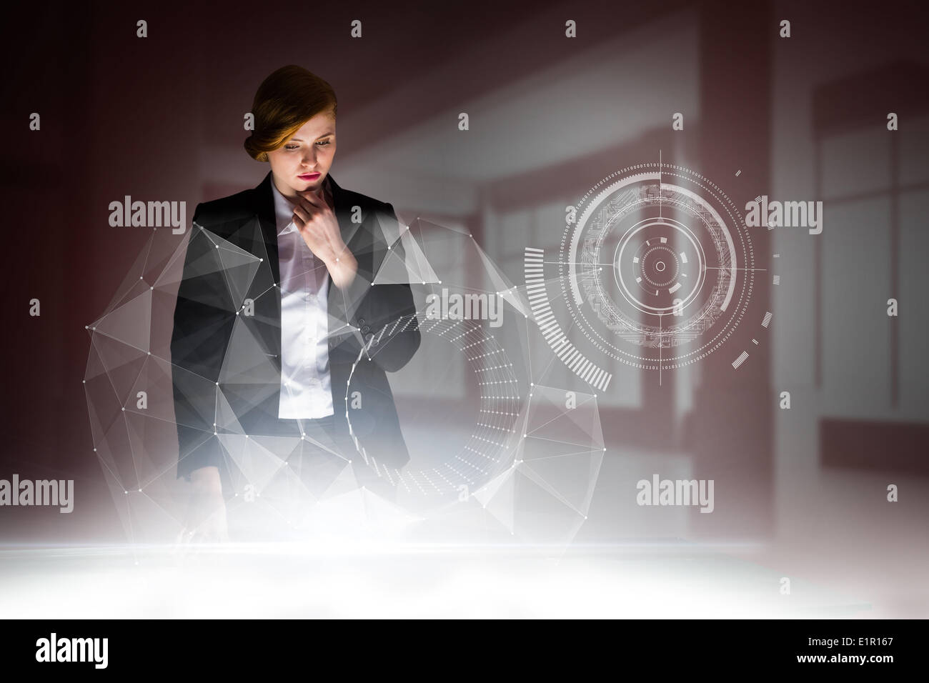 Composite image of redhead businesswoman using interactive desk Stock Photo
