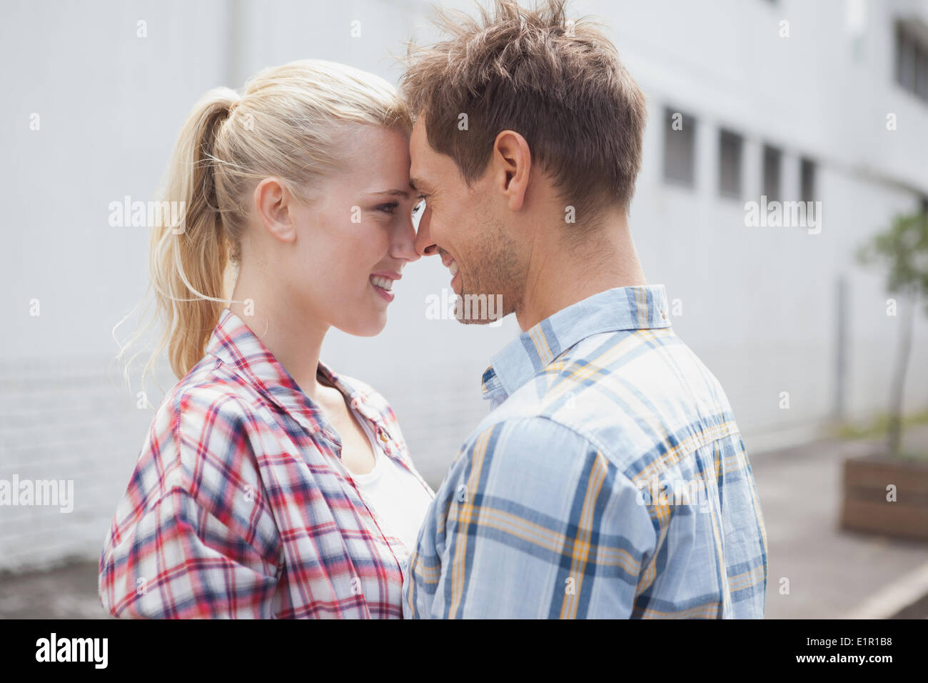 Hip young couple hugging and facing each other Stock Photo