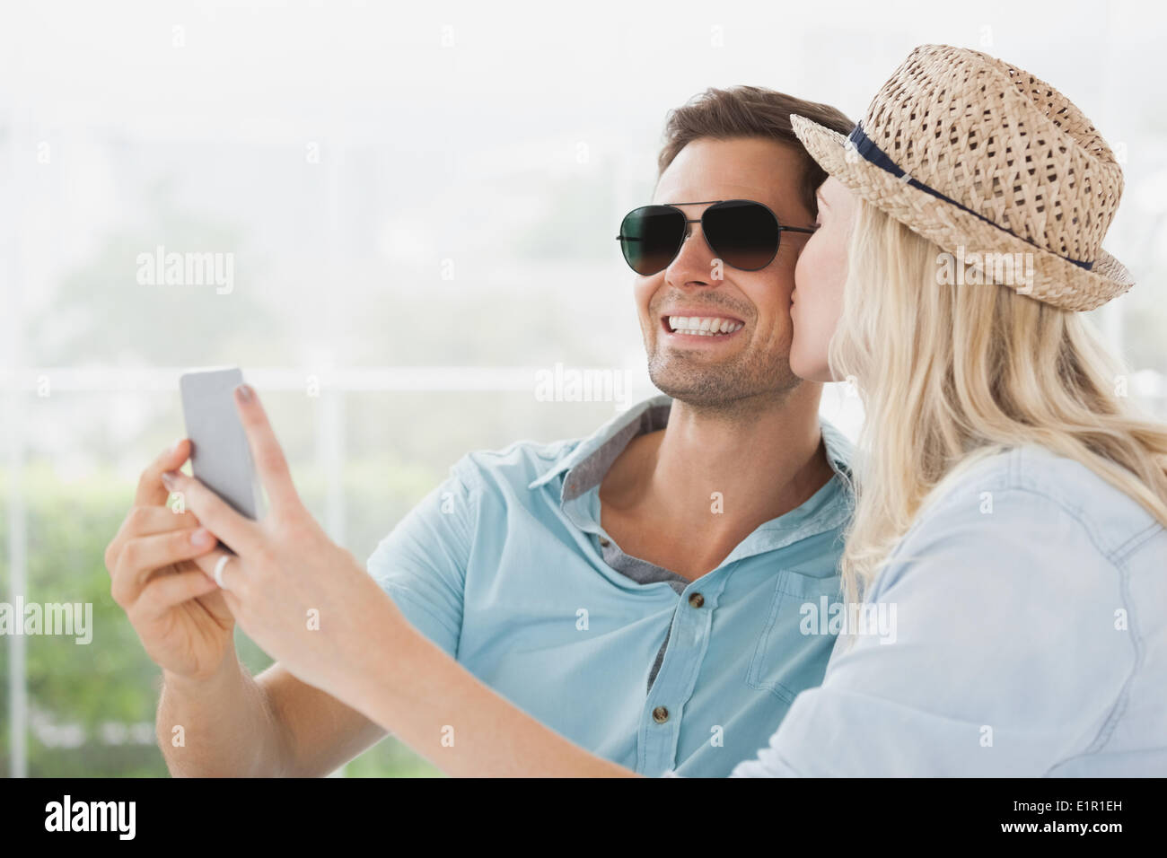Cute couple sitting in cafe taking a selfie Stock Photo