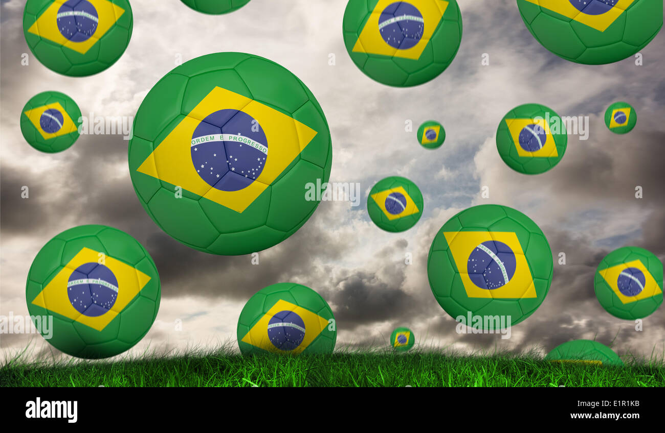 Composite image of footballs in brasil flag colours Stock Photo