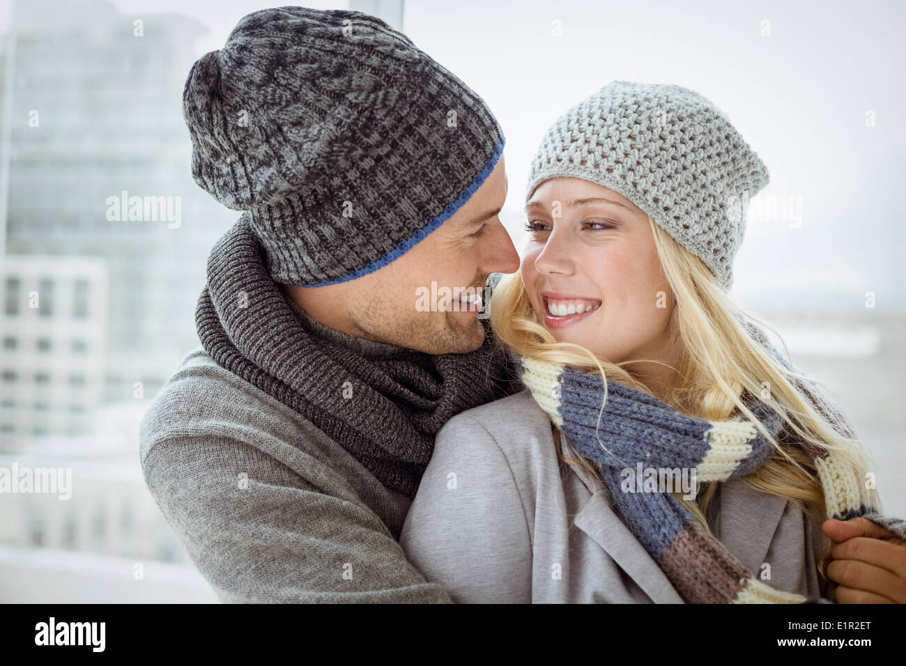 Cute couple in warm clothing smiling at each other Stock Photo - Alamy