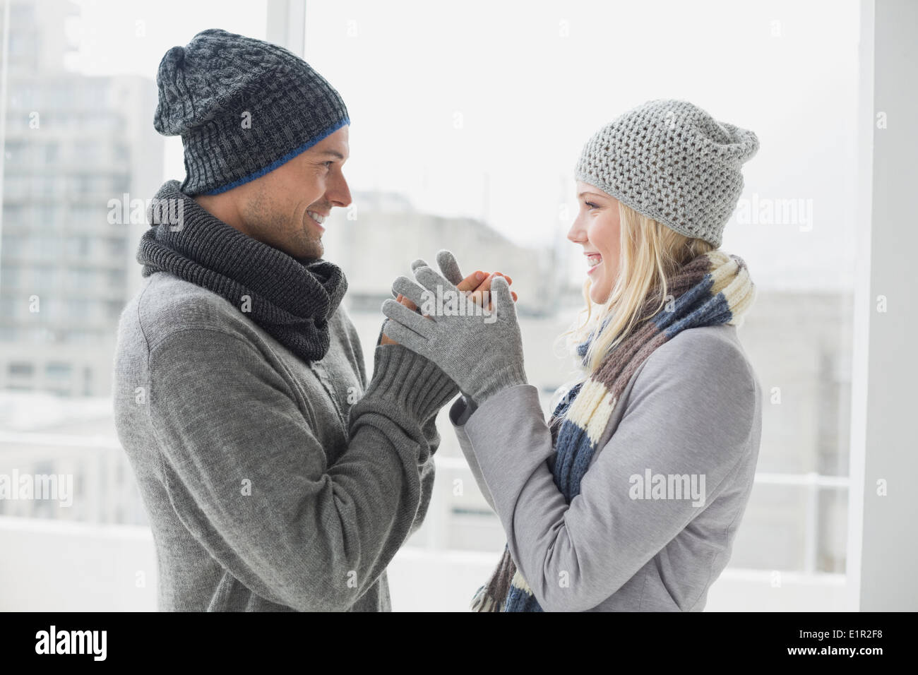 Cute couple in warm clothing smiling at each other Stock Photo - Alamy