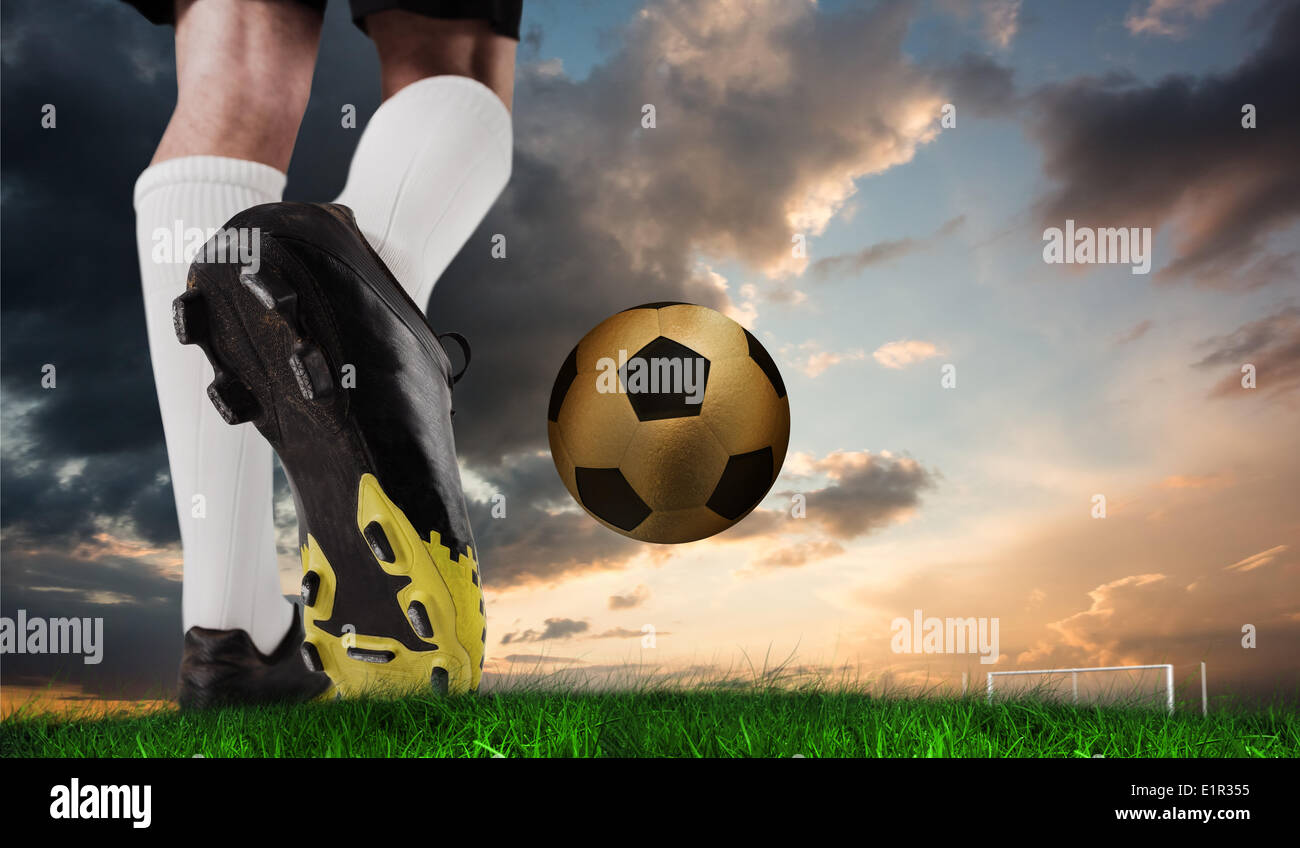 Composite image of football boot kicking gold ball Stock Photo