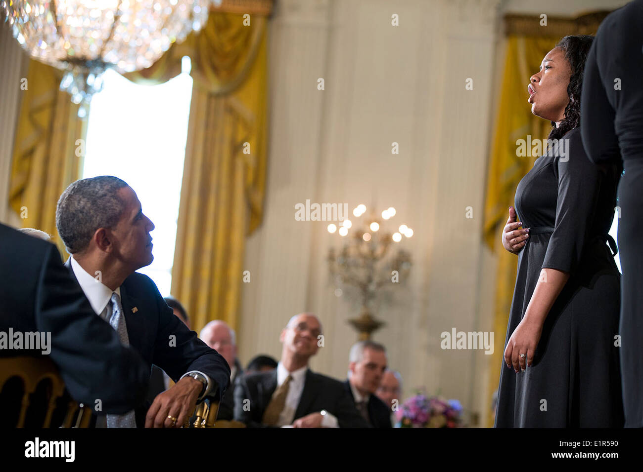 US President Barack Obama watches the Children of the Gospel Choir perform during the Easter Prayer Breakfast in the East Room of the White House April 14, 2014 in Washington, DC. Stock Photo