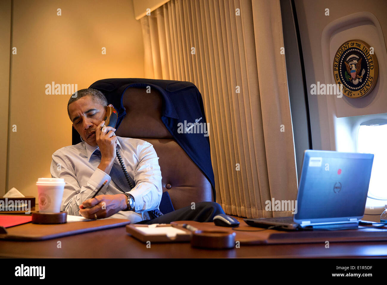US President Barack Obama talks on the phone in his office aboard