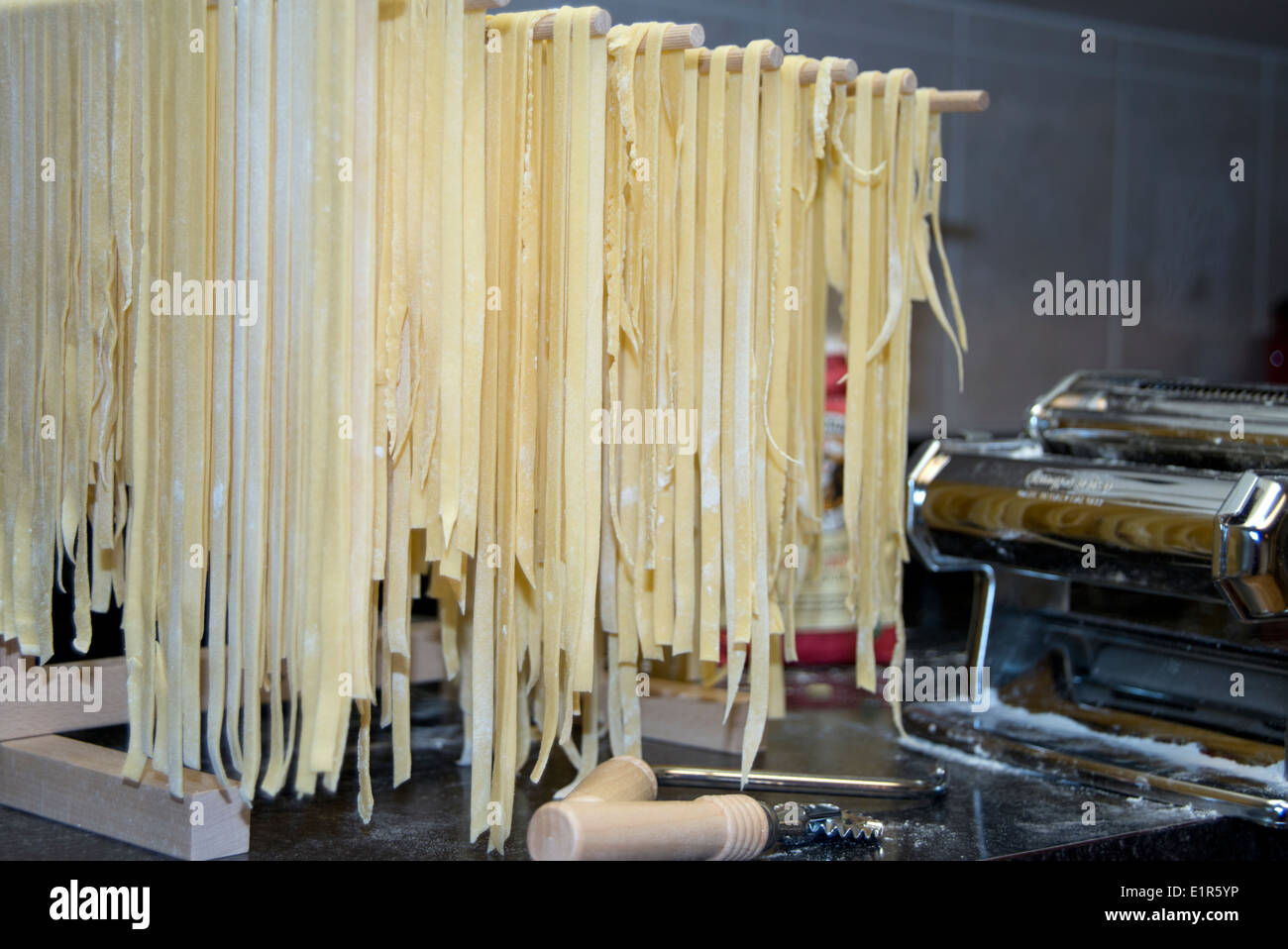 Homemade pasta drying on a rack with pasta machine Stock Photo Alamy