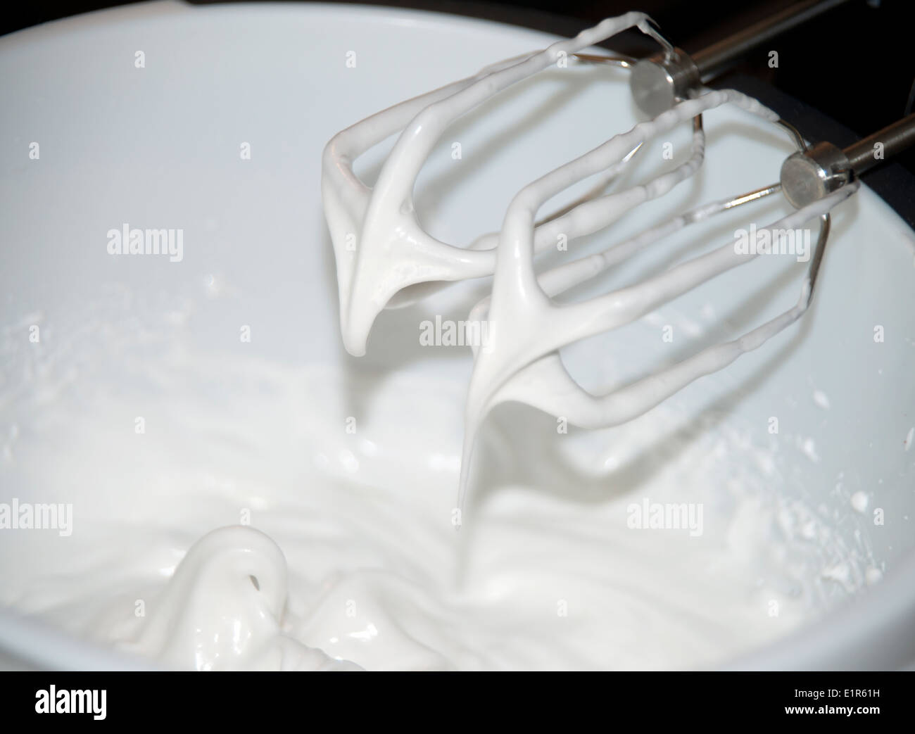 Egg whites whipped to soft peaks with mixer beaters Stock Photo