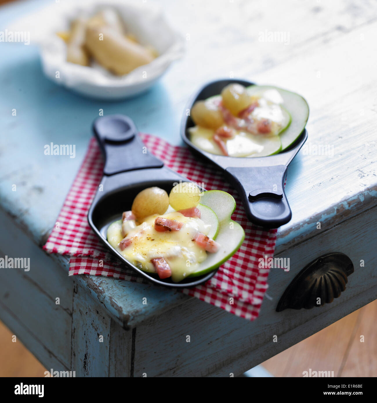 Normany Camembert Raclette with grapes,diced bacon and apples Stock Photo