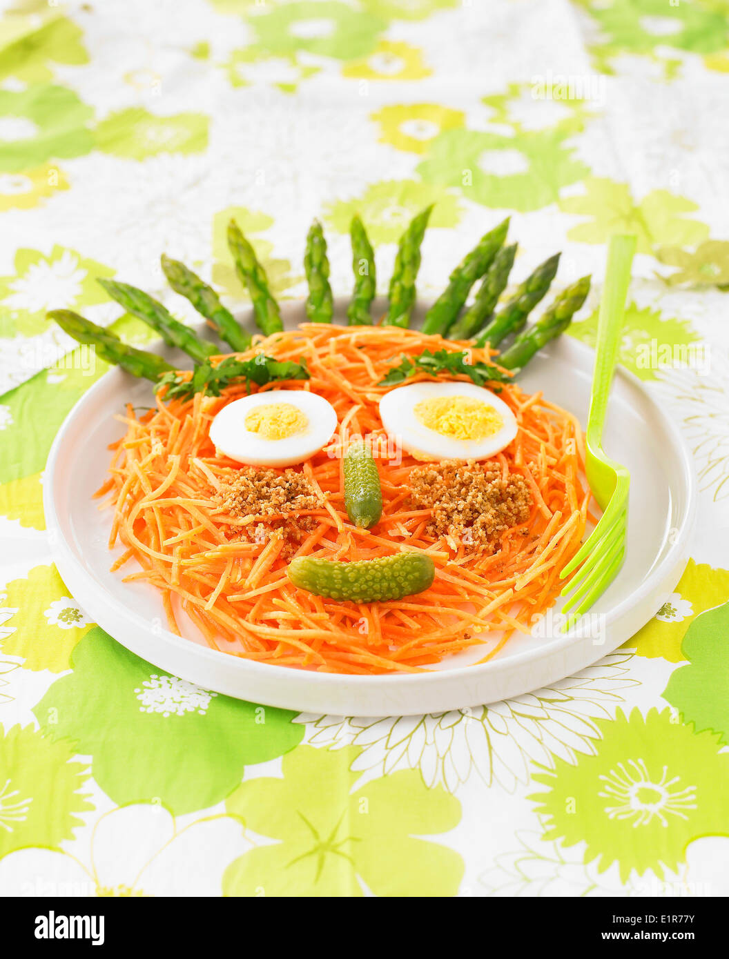 Face-shaped grated carrot and asparagus salad Stock Photo