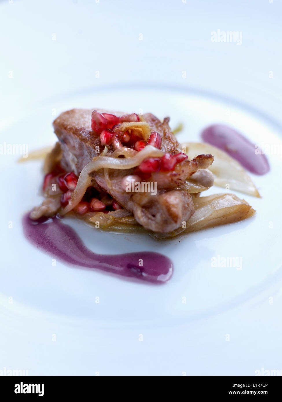 Veal with pan-fried chicory,red onion butter and pomegranate seeds Stock Photo