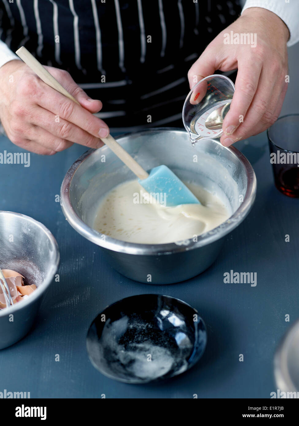 Adding the peanut oil to the pancake batter Stock Photo