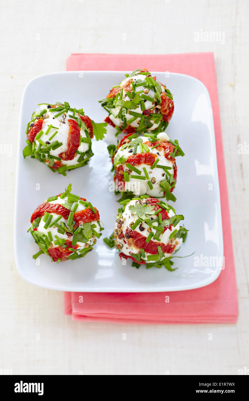 Fresh goat's cheese balls coated in sun-dried tomatoes and chives Stock Photo