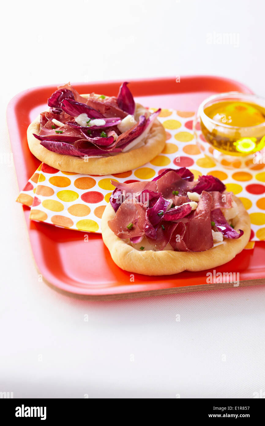 Chicory,grisons meat and parmesan flake mini pizzas Stock Photo